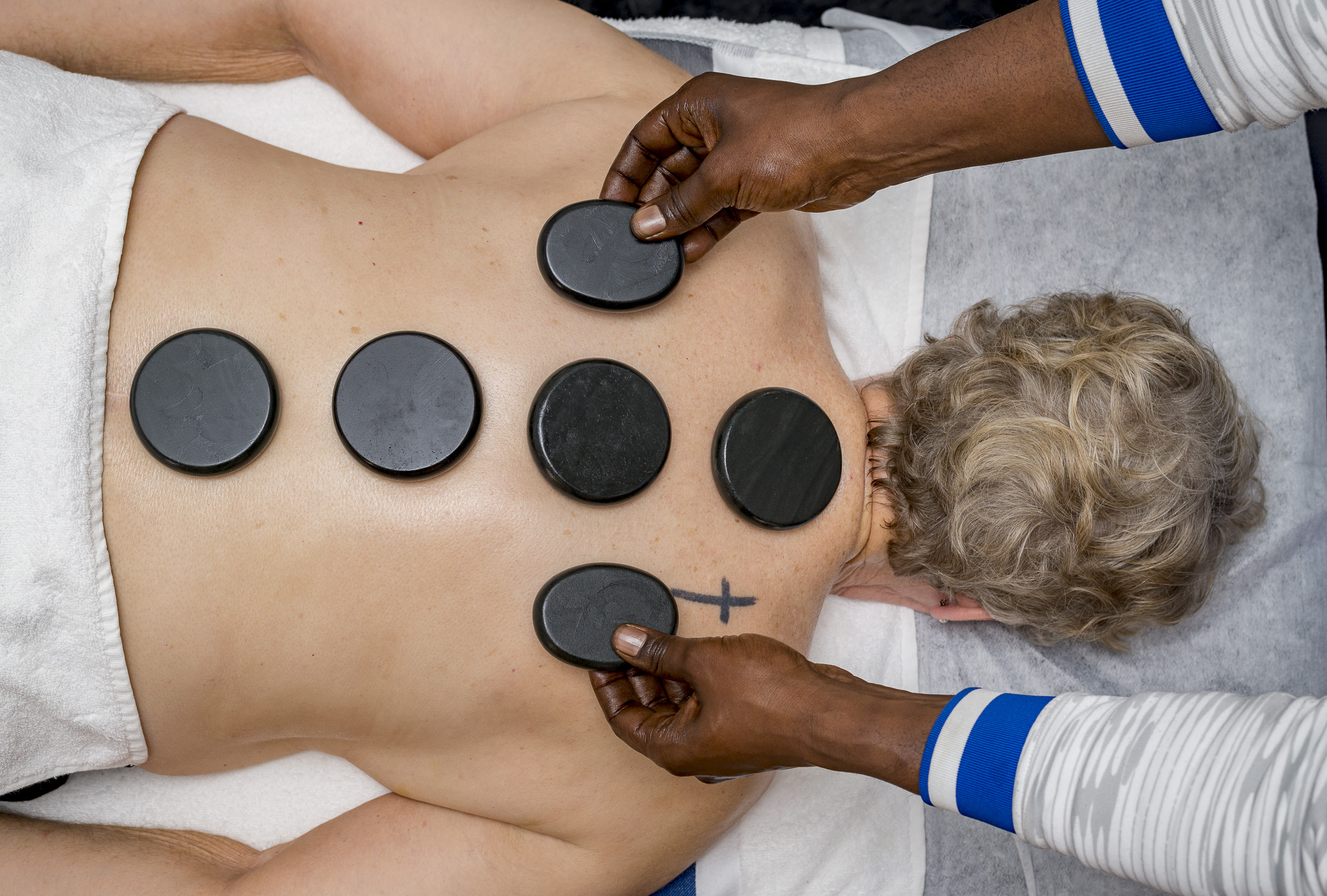 Maykel Dihigo en un masaje en una terapia manual con piedras calientes para la salud y el bienestar